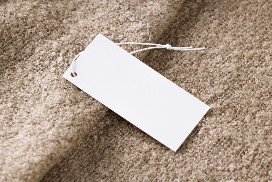 Étiquette de prix vierge posée sur un tissu beige