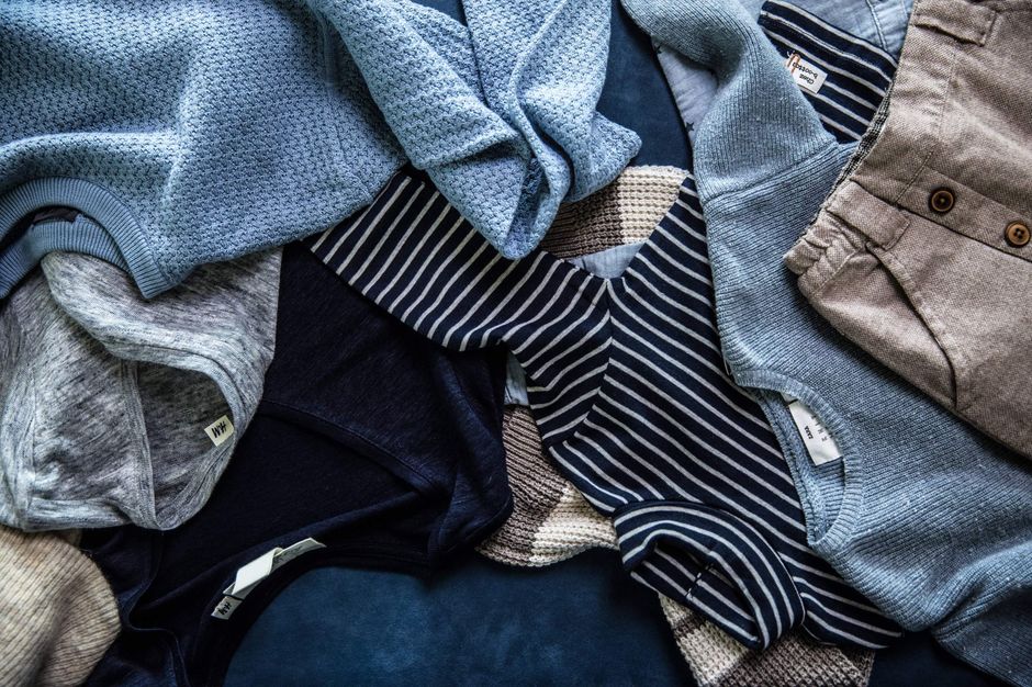 Vêtements d'enfant dans des tons bleus posés côte à côte