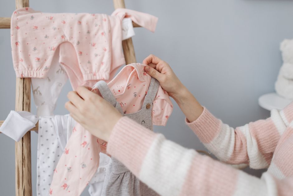 Vêtements de bébé suspendus sur un portant en bois
