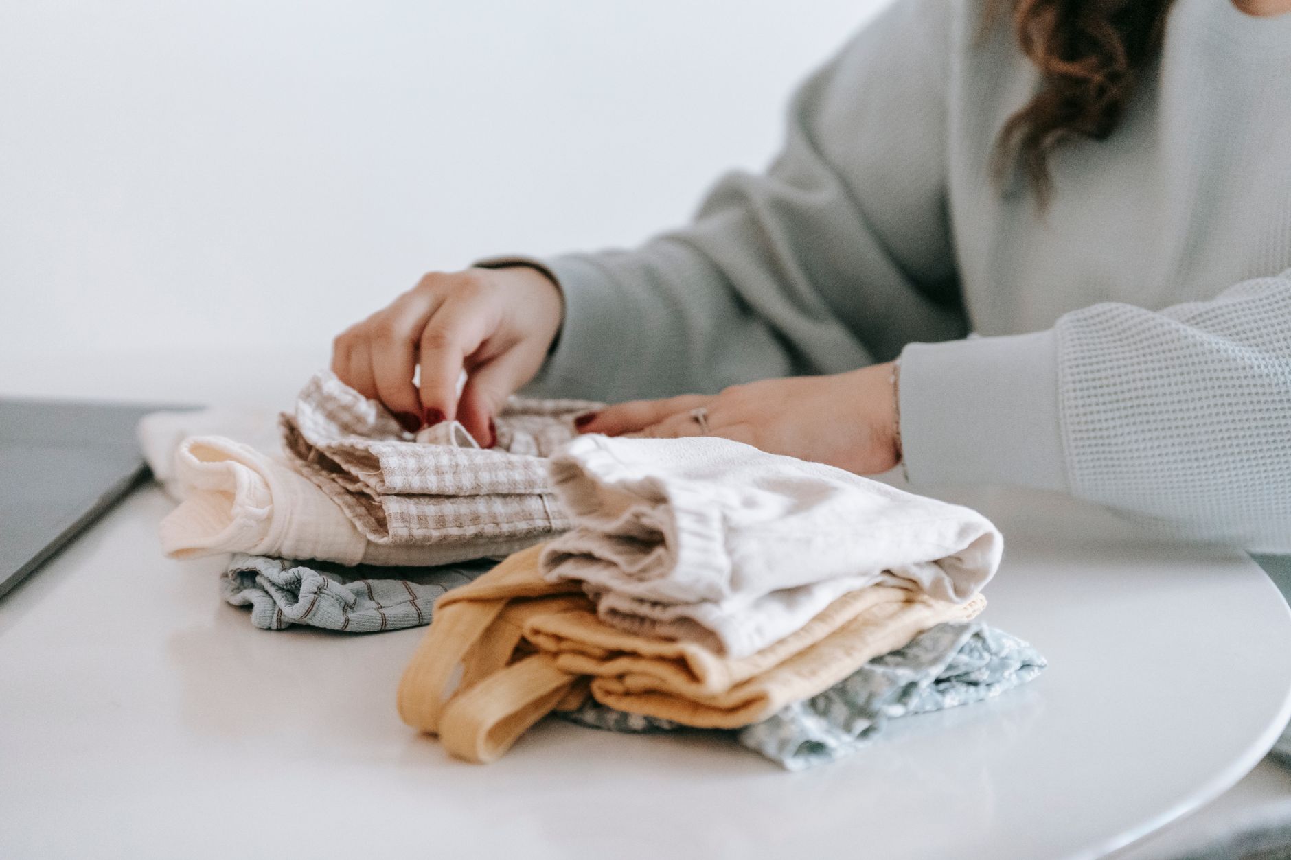 Femme pliant et rangeant des vêtements sur une table