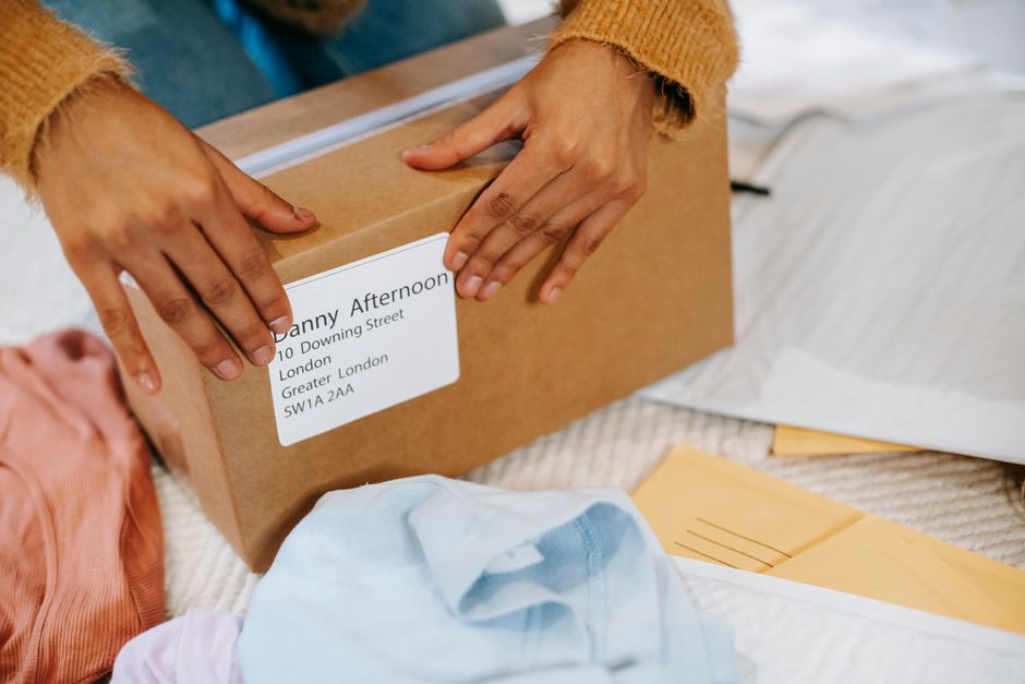 Mains refermant un colis en carton