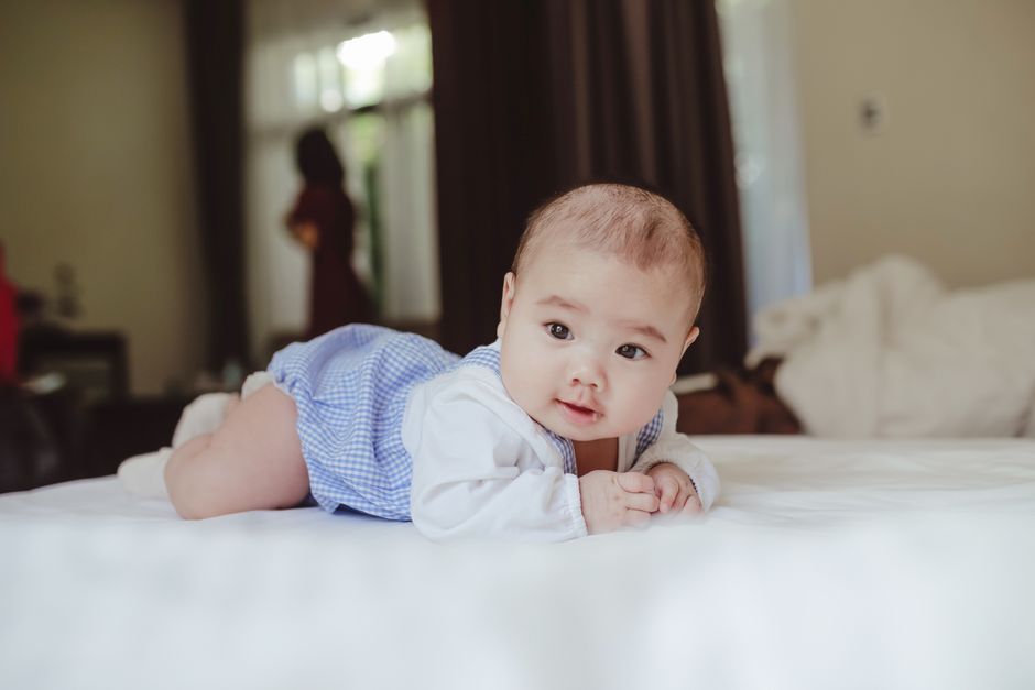 Bébé allongé portant un body bleu